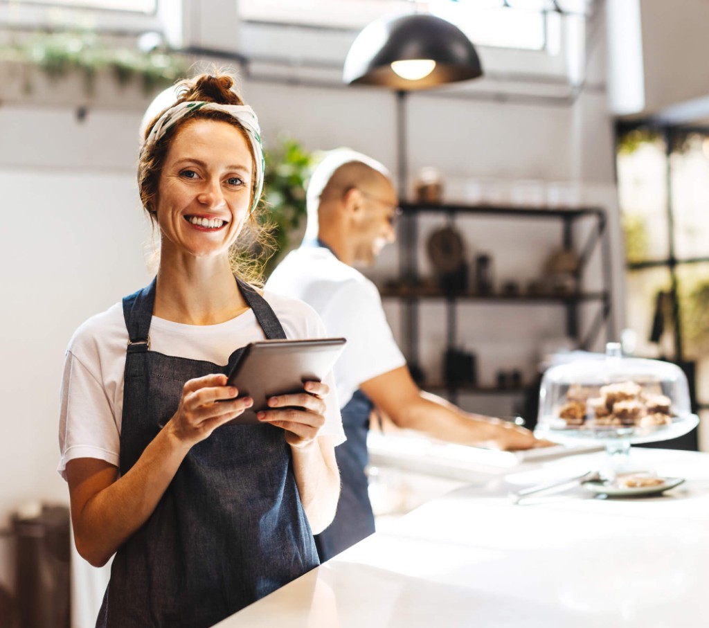 Unternehmerin in ihrem Café mit einem Tablet